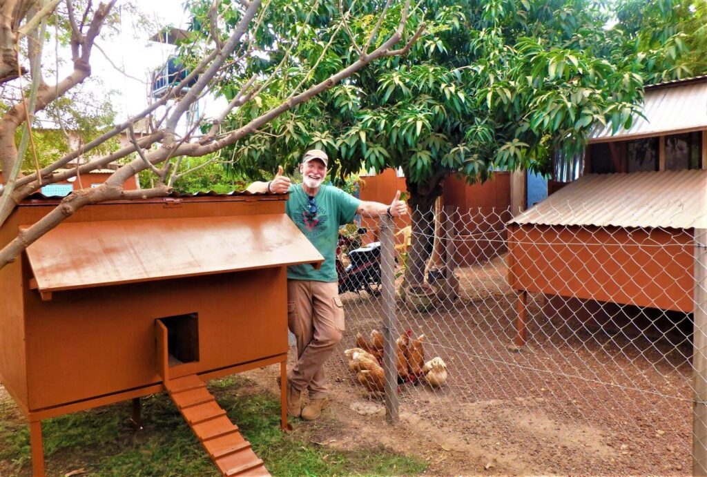 Don Standing and Smiling Infront of a Chicken Coop
